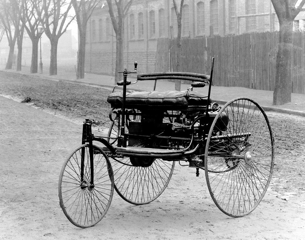 The Benz Patent-Motorwagen, a three-wheeled carriage with large spoked wheels and a rear-mounted engine